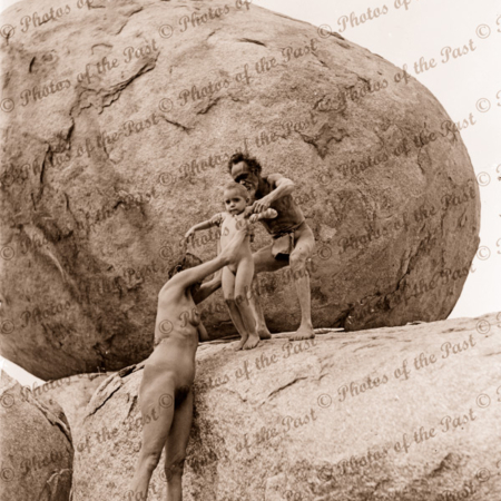 Aborigine family climbing rock, Devils Marbles, near Tennant Creek NT. c1936. Northern Territory