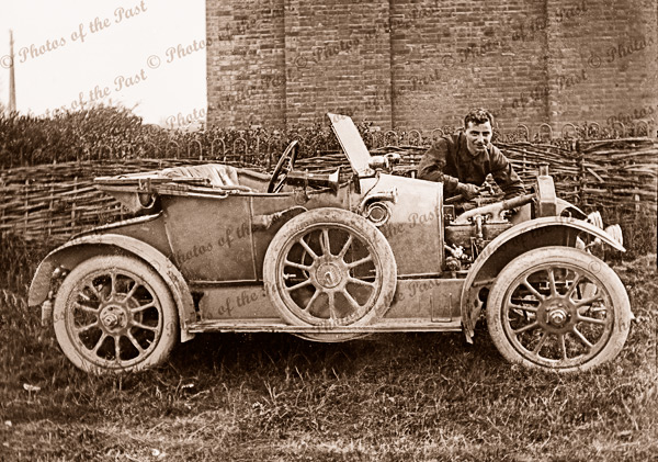 Repairing old touring car with man next to open bonnet.1910s