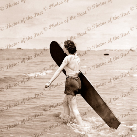Woman with board going for a surf. c1940s. Surfing