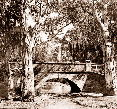 Old Belair Road bridge crossing Brown Hill Creek from eastern side. South Australia. Stone bridge, large gum trees. C1899