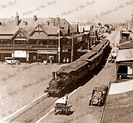 Looking east along Jetty Road, Glenelg, South Australia. Showing train, cars. C1920