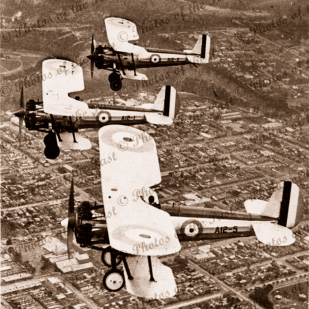 Three Bristol Bulldog bi-planes in flight, Victoria. City beneath.