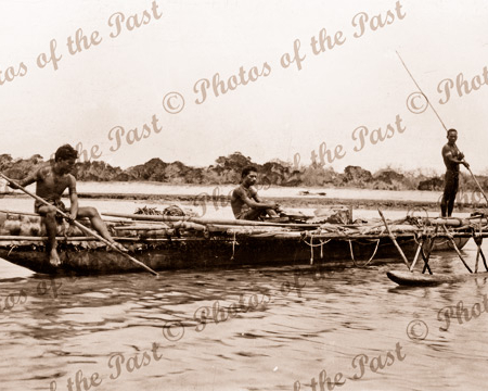 A large native out-rigger canoe. Three young men on board. Papua New Guinea. 1916