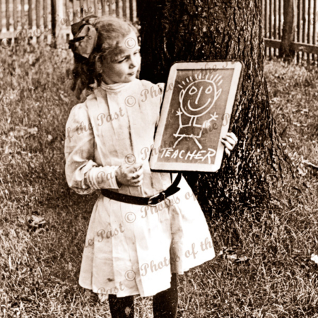Young school girl with slate board with sketch of her teacher. c1900